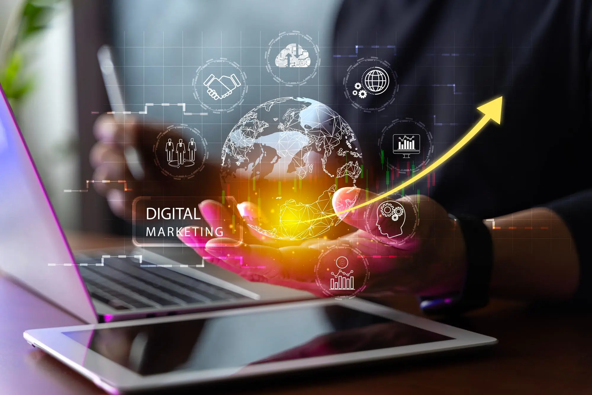 Digitales Marketing: Kennzahlen und Symbole schweben über Laptop und Tablet
